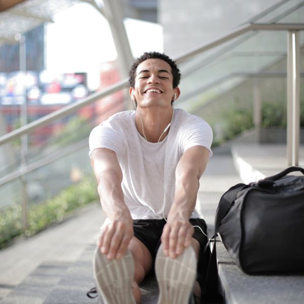 Man outdoors looking content and relaxed after a workout session.